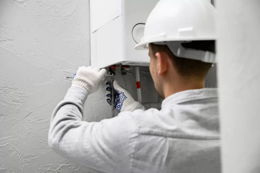 Gas engineer performing maintenance on a modern boiler system in a home.