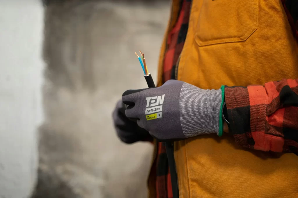Electrician employed through a Recruitment Agency East Kilbride holding a stripped, live wire.