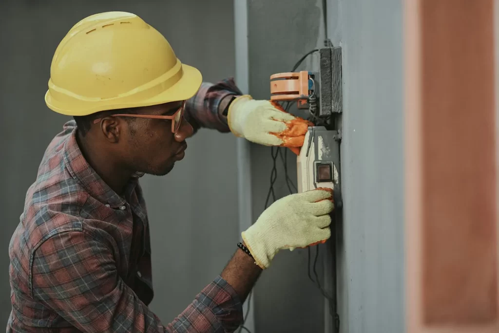 Electrician working on electrical installation, representing hands-on electrician jobs in Scotland.