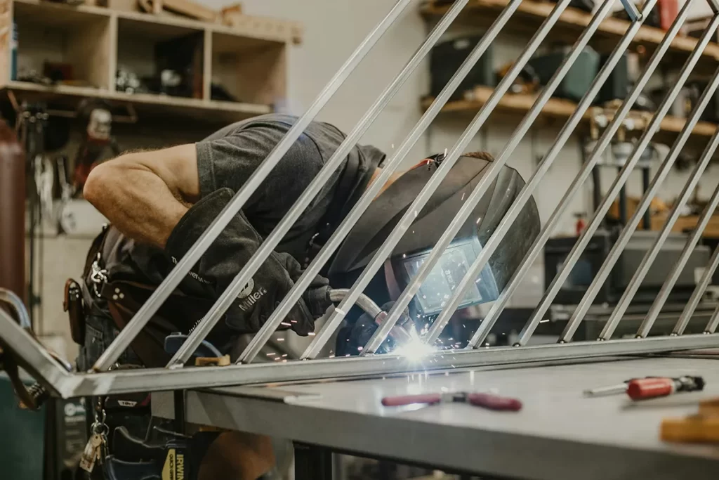 elder carefully welding a metal fence, demonstrating the practical skills involved in Welder / Fabrication jobs Hamilton.
