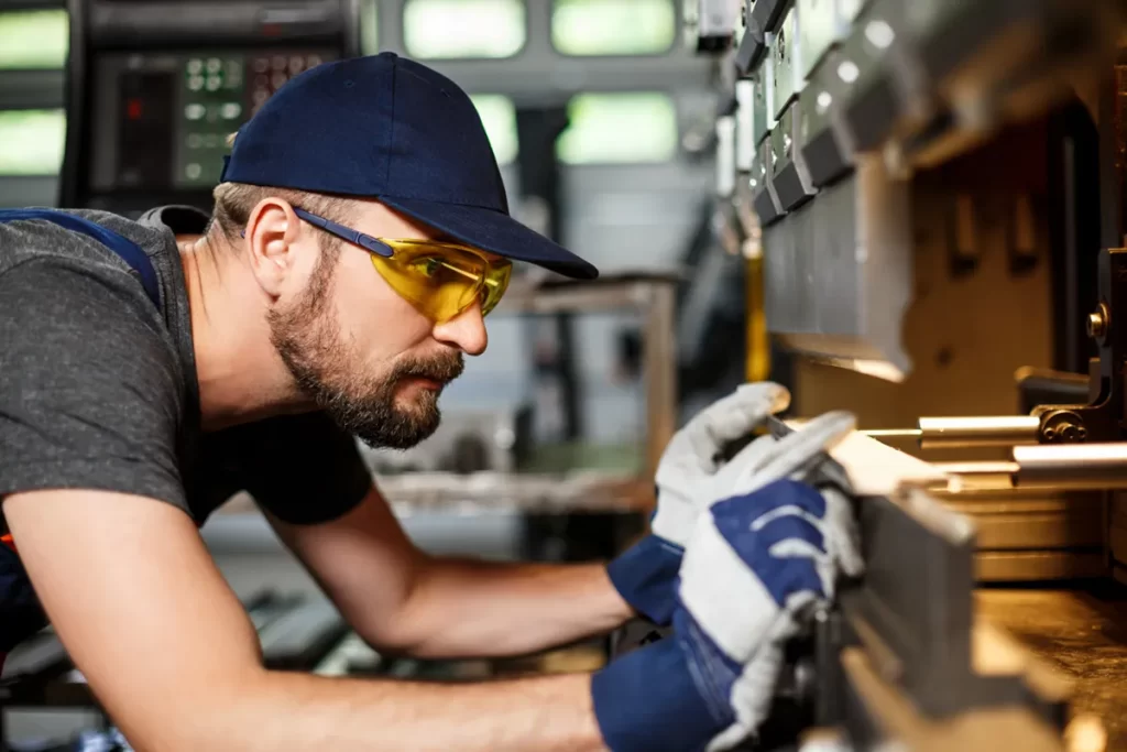 Worker using a metalworking machine, highlighting opportunities in CNC's jobs Scotland within the manufacturing sector.