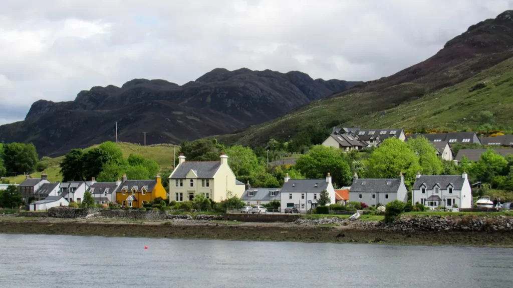 Charming Scottish seaside village with colorful houses along the waterfront, representing opportunities for Electrical Engineer Jobs Scotland in coastal communities.