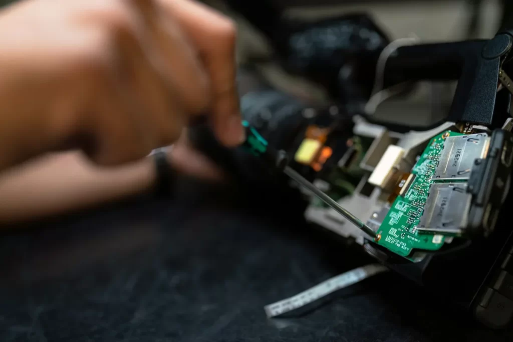 Close-up of a hand carefully working on electronic components with tools, representing the skills and precision needed for Electrical Engineer Jobs Glasgow.